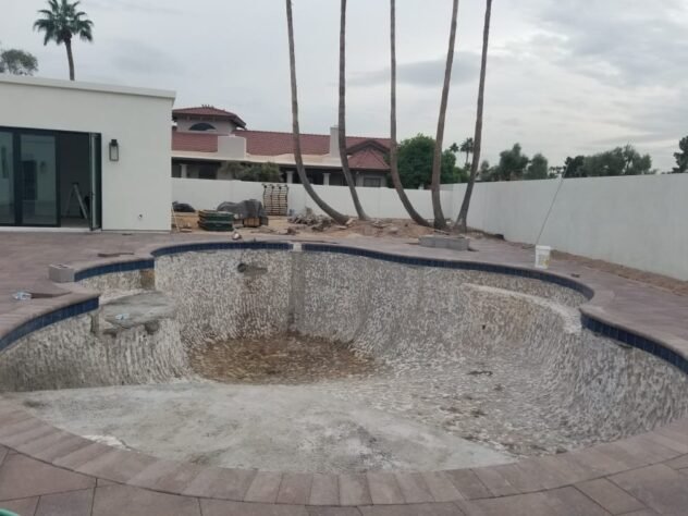 Worn and stained swimming pool interior before resurfacing in Mesa, AZ